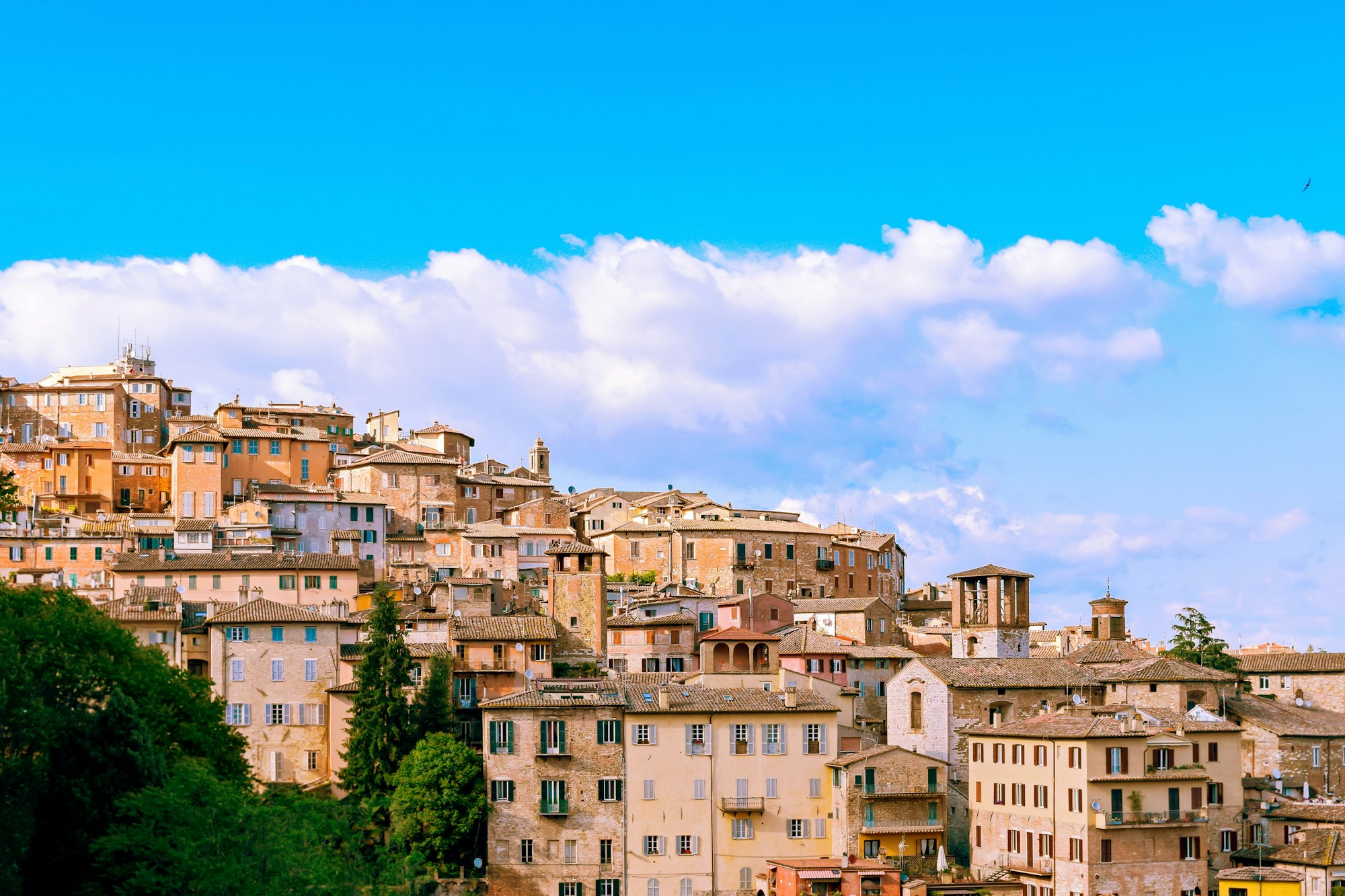 Perugia skyline under azure blue sky. Landscape with old Italian town with medieval houses on a hill
